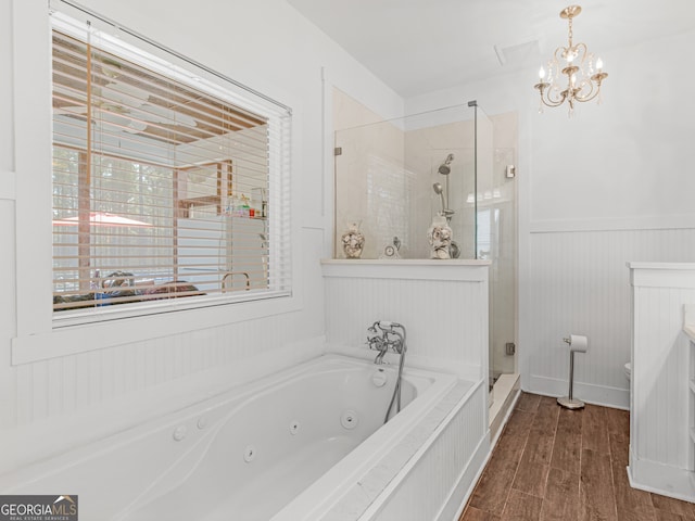 bathroom with toilet, hardwood / wood-style flooring, shower with separate bathtub, and an inviting chandelier