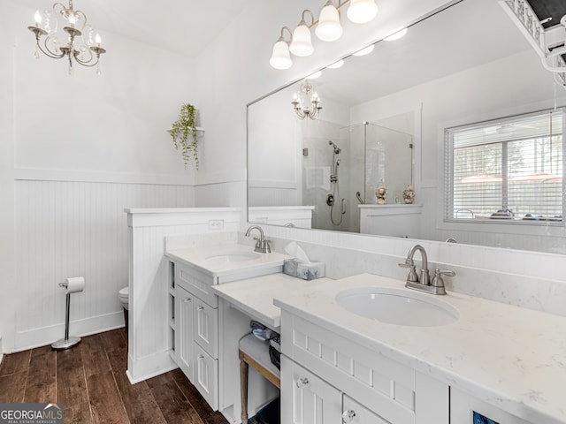 bathroom featuring walk in shower, wood-type flooring, a notable chandelier, and vanity