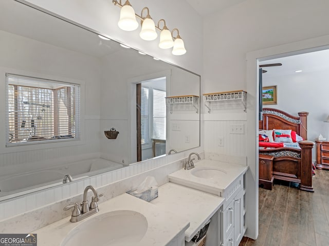 bathroom with vanity, hardwood / wood-style floors, and a washtub