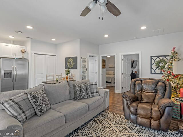 living room with wood-type flooring and ceiling fan