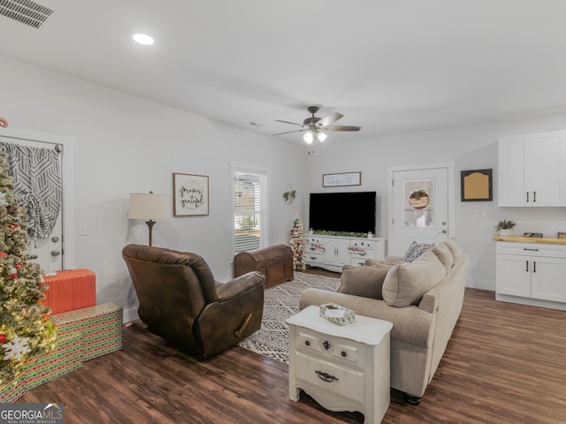 living room featuring dark wood-type flooring and ceiling fan