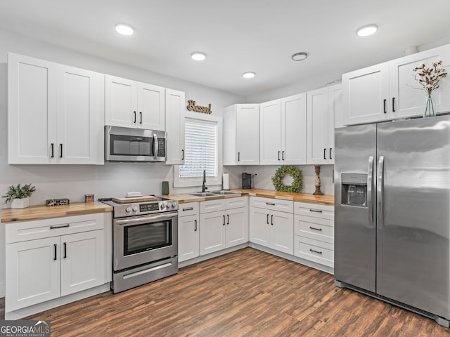 kitchen featuring white cabinets, stainless steel appliances, dark hardwood / wood-style floors, and butcher block counters