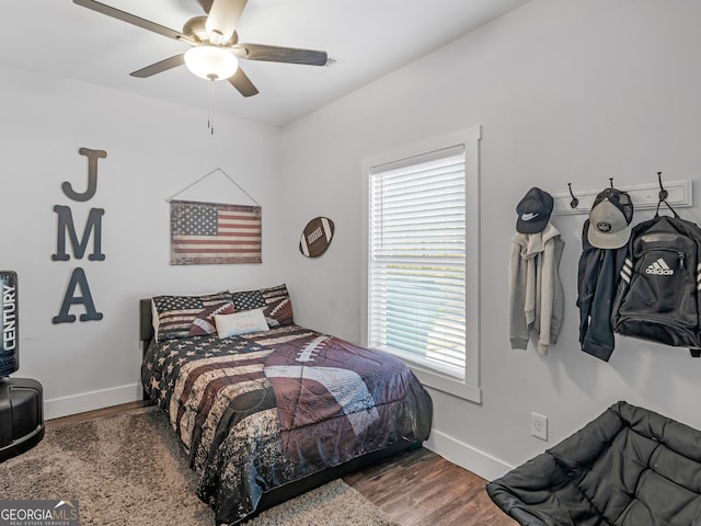 bedroom with multiple windows, wood-type flooring, and ceiling fan