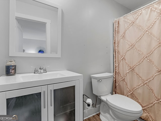 bathroom with vanity, toilet, and hardwood / wood-style floors