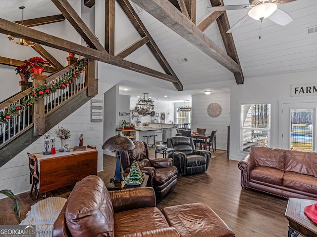 living room featuring beamed ceiling, hardwood / wood-style floors, ceiling fan, and wood walls