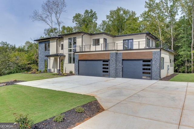 contemporary home with a garage, a front lawn, and a balcony