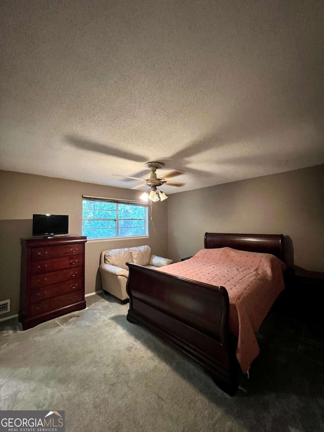 bedroom featuring ceiling fan, a textured ceiling, and carpet flooring