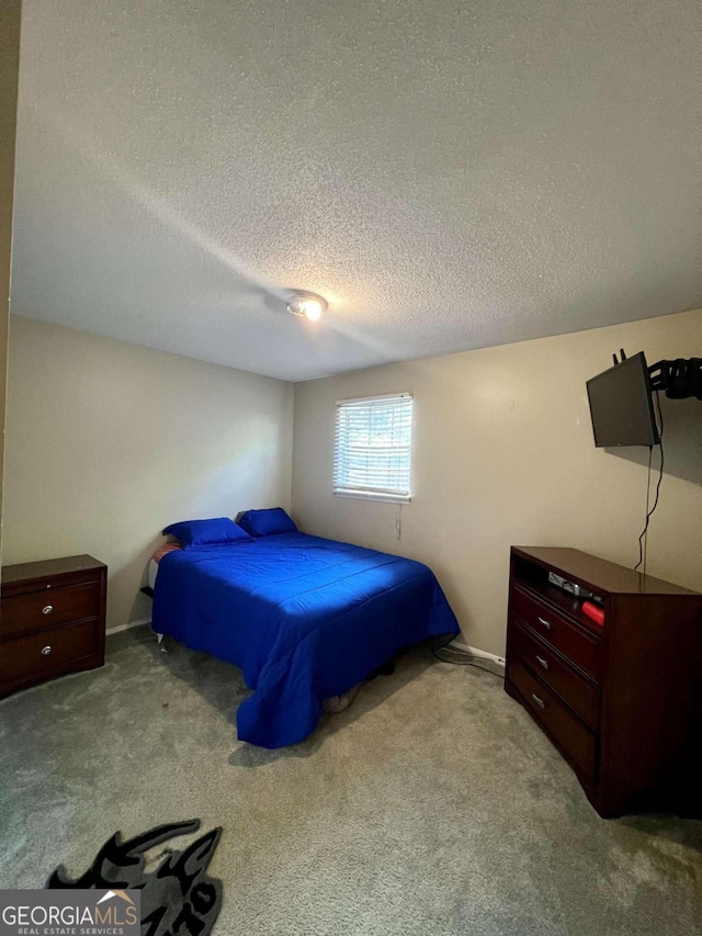 bedroom featuring a textured ceiling and light colored carpet