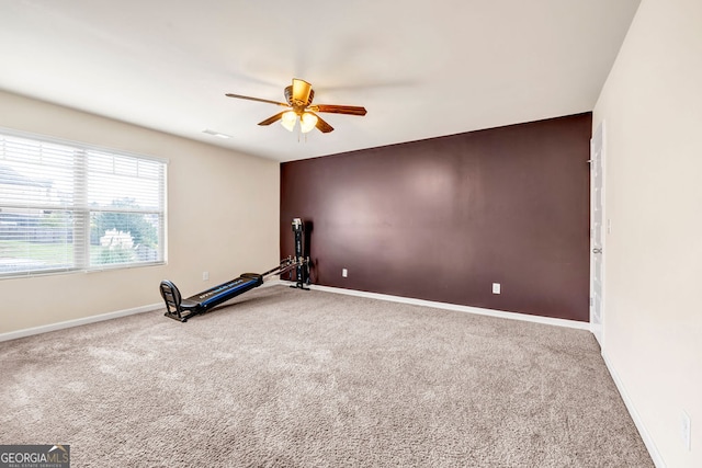 workout room with ceiling fan and carpet