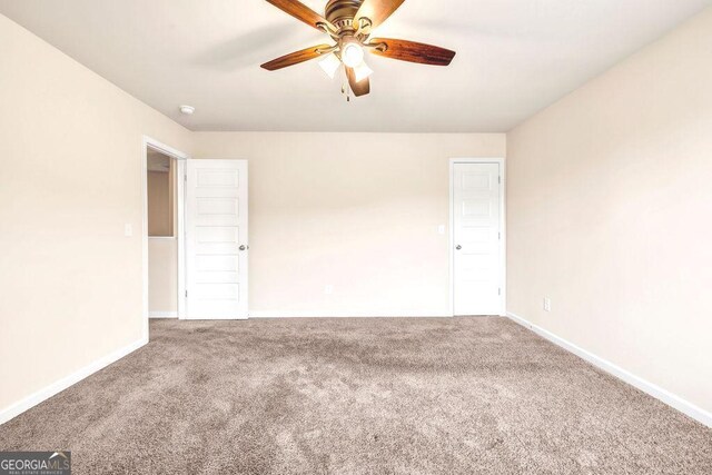 carpeted empty room featuring ceiling fan