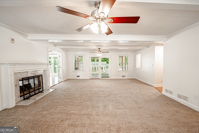 unfurnished living room featuring ceiling fan, light colored carpet, a fireplace, and ornamental molding