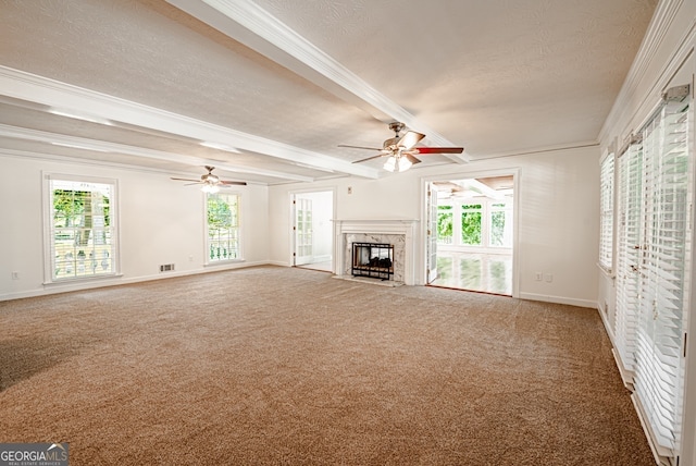 unfurnished living room with beamed ceiling, a textured ceiling, and a high end fireplace