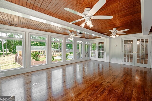 unfurnished sunroom with wood ceiling, ceiling fan, plenty of natural light, and french doors