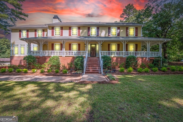 view of front of property featuring a porch and a lawn