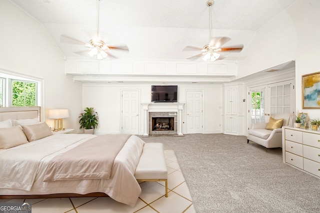 carpeted bedroom with high vaulted ceiling, ceiling fan, and a fireplace