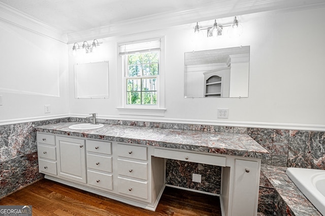 bathroom with ornamental molding, hardwood / wood-style floors, a washtub, and vanity