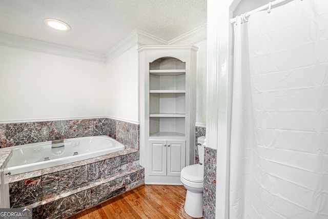 bathroom featuring wood-type flooring, a textured ceiling, a bathing tub, crown molding, and toilet