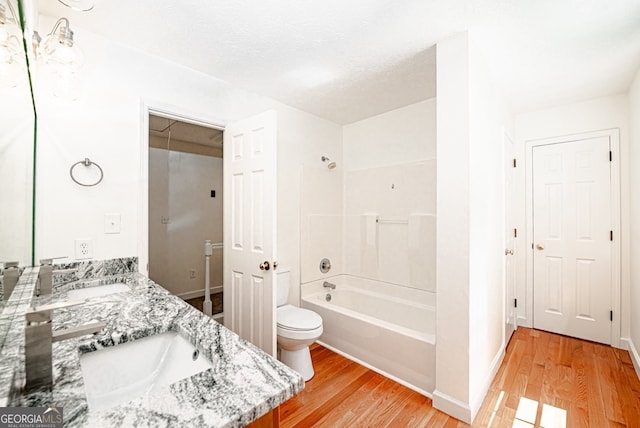 full bathroom featuring vanity, shower / bathtub combination, hardwood / wood-style floors, and toilet