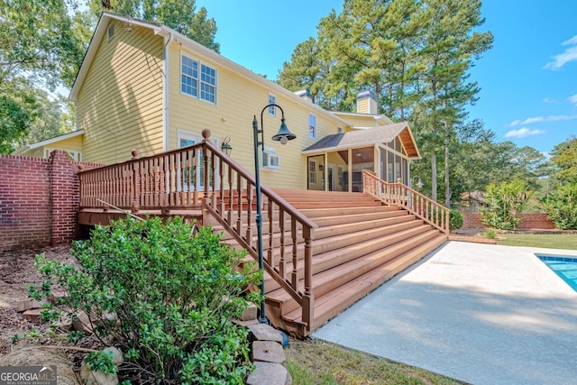 back of house featuring a pool side deck and a sunroom