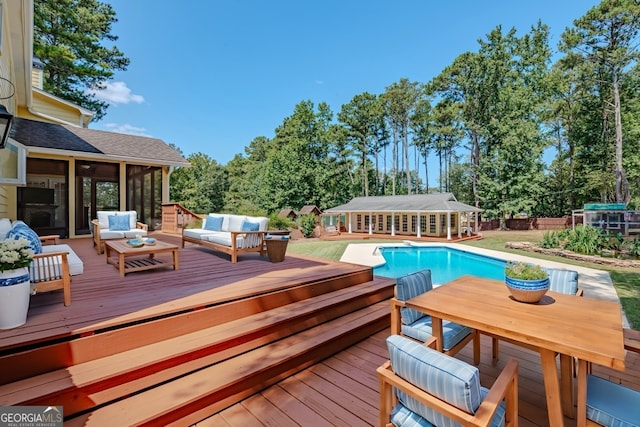 view of swimming pool with a sunroom, outdoor lounge area, and a deck