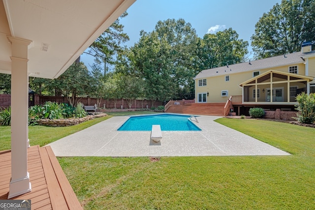 view of pool with a lawn, a diving board, a patio, and a wooden deck