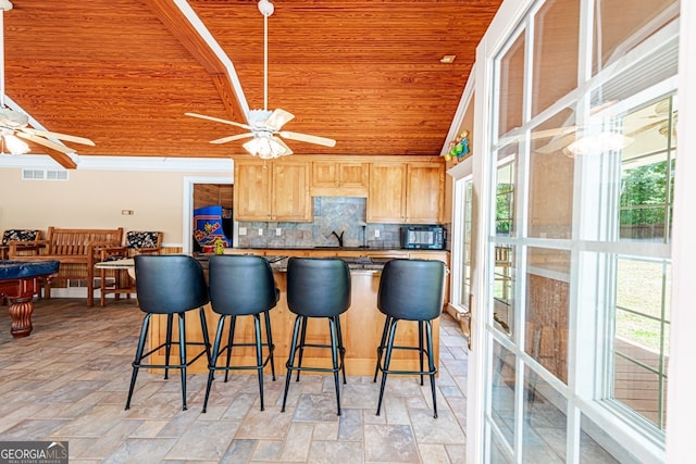 kitchen featuring ceiling fan, light brown cabinetry, wooden ceiling, and tasteful backsplash