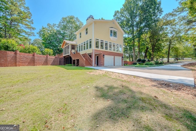 3060 Orchard Rd SW, Conyers, GA 30094 - back of house with a sunroom, an attached garage, a chimney, concrete driveway, and brick siding