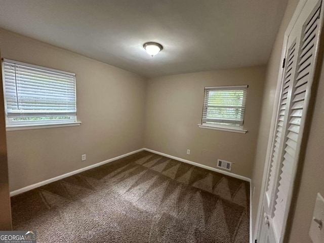 unfurnished bedroom with carpet flooring and multiple windows