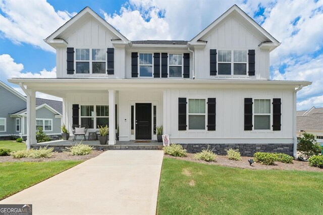 view of front of house with a porch and a front lawn