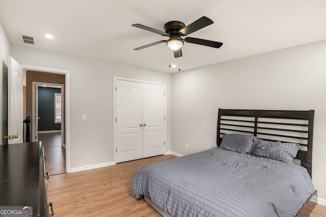 bedroom with ceiling fan, light wood-type flooring, and a closet