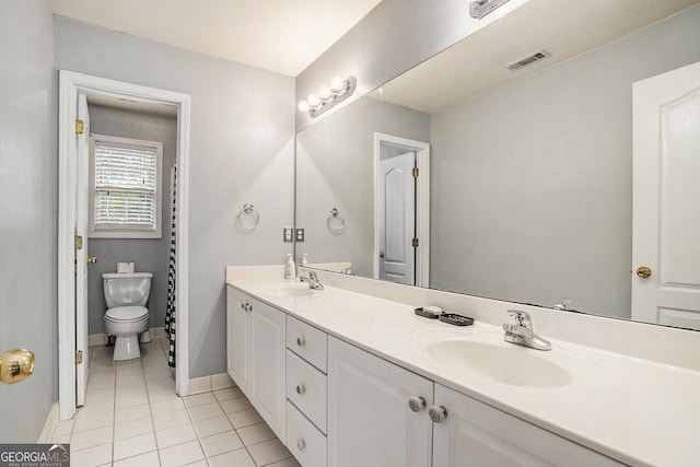 bathroom with tile patterned flooring, vanity, and toilet