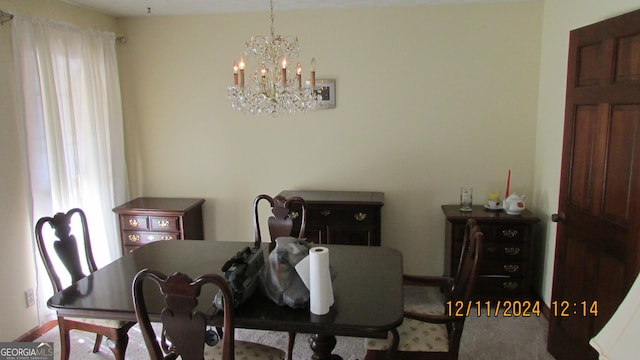 dining room with carpet flooring and an inviting chandelier