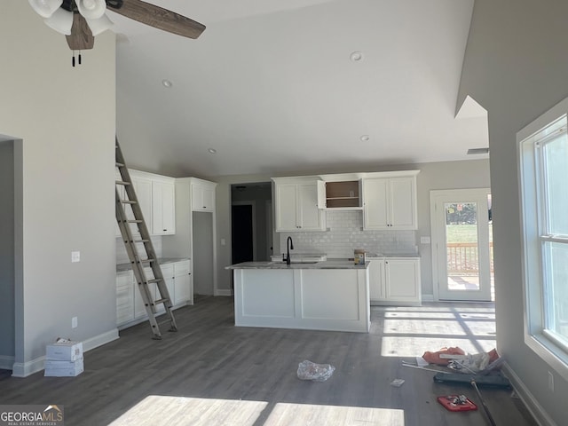 kitchen with ceiling fan, a healthy amount of sunlight, white cabinetry, and an island with sink