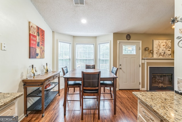 dining space featuring dark wood-type flooring and a textured ceiling