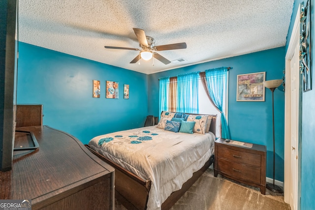 carpeted bedroom with ceiling fan and a textured ceiling