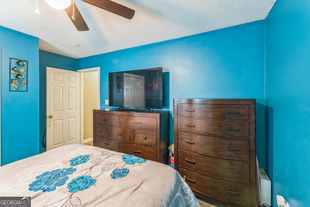 bedroom with ceiling fan and a textured ceiling