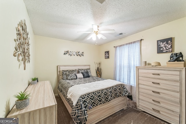 carpeted bedroom with a textured ceiling and ceiling fan