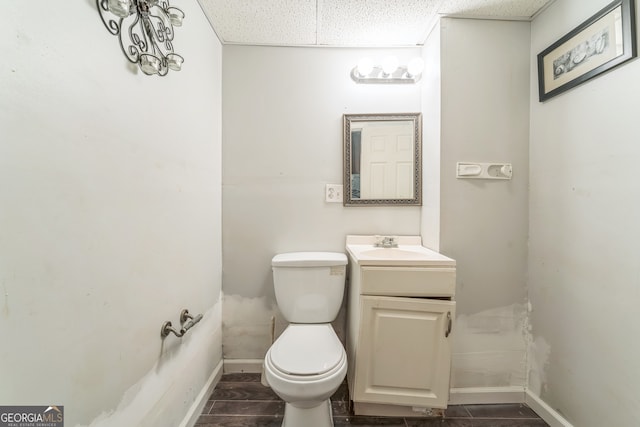 bathroom with toilet, a textured ceiling, and vanity