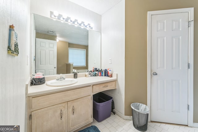 bathroom with vanity, a textured ceiling, and tile patterned floors