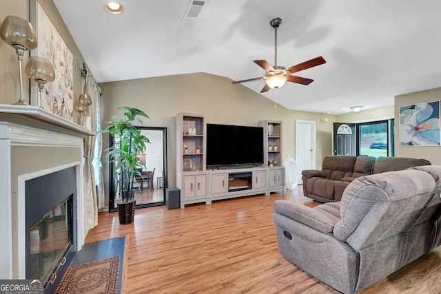 living room featuring light hardwood / wood-style flooring, vaulted ceiling, and ceiling fan