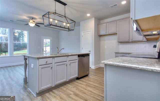 kitchen featuring decorative light fixtures, light hardwood / wood-style floors, ceiling fan, a kitchen island with sink, and stainless steel dishwasher