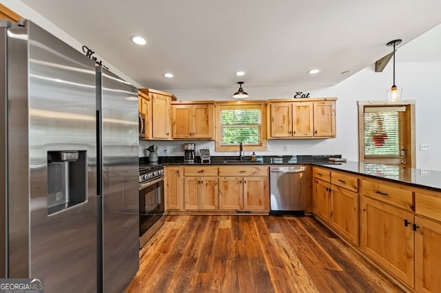 kitchen featuring dark hardwood / wood-style flooring, sink, hanging light fixtures, and appliances with stainless steel finishes