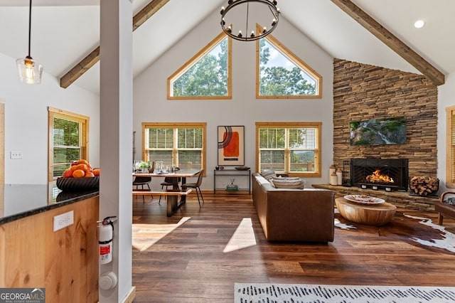 living room featuring a stone fireplace, dark hardwood / wood-style flooring, high vaulted ceiling, and a healthy amount of sunlight