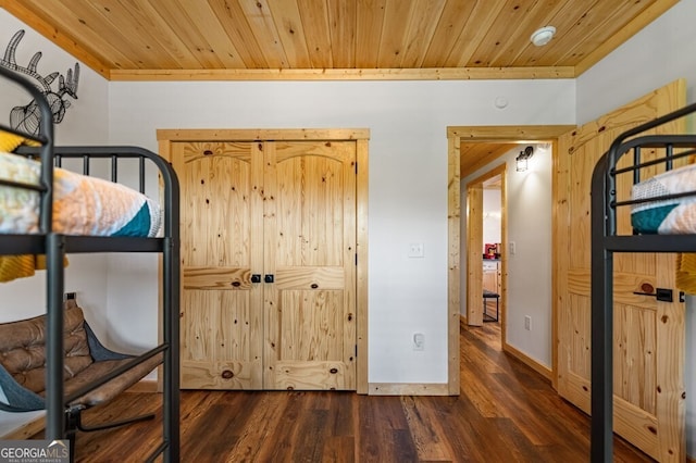 unfurnished bedroom with dark hardwood / wood-style flooring and wooden ceiling