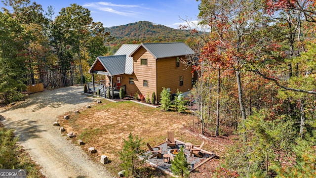 exterior space featuring a mountain view, a porch, and an outdoor fire pit