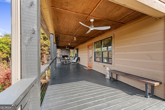 wooden terrace with a porch and ceiling fan