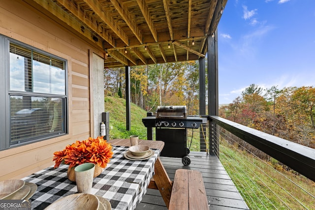 wooden balcony with a grill and a wooden deck