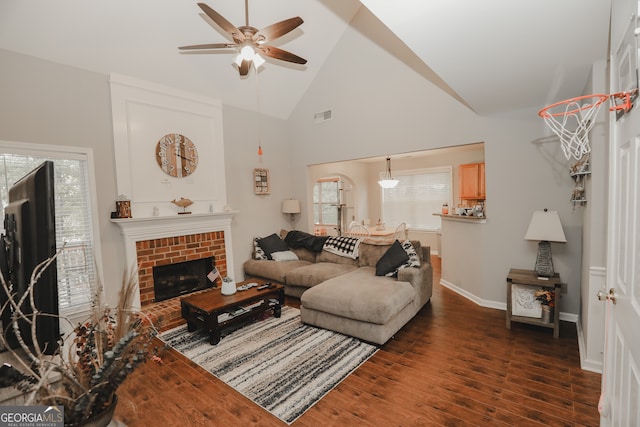 living room featuring high vaulted ceiling, ceiling fan, dark hardwood / wood-style floors, and a brick fireplace