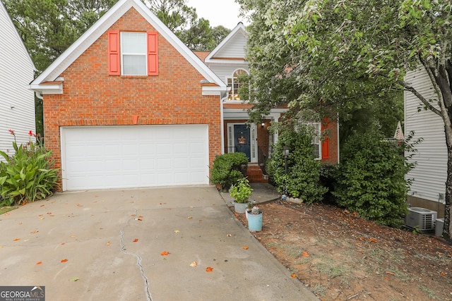 traditional-style home featuring cooling unit, brick siding, concrete driveway, and an attached garage