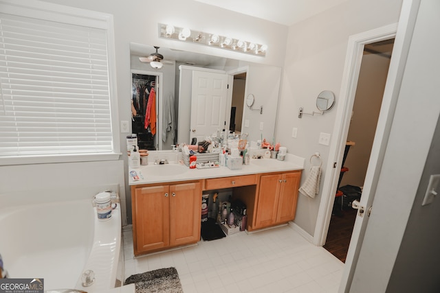 bathroom with tile patterned floors, ceiling fan, a bathing tub, and vanity